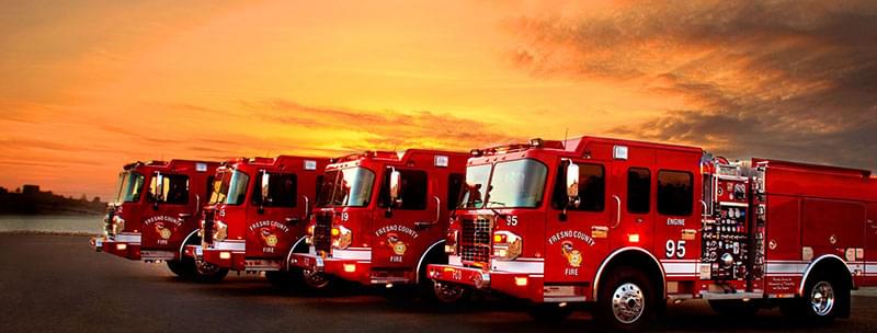 Four fire trucks parked at sunset